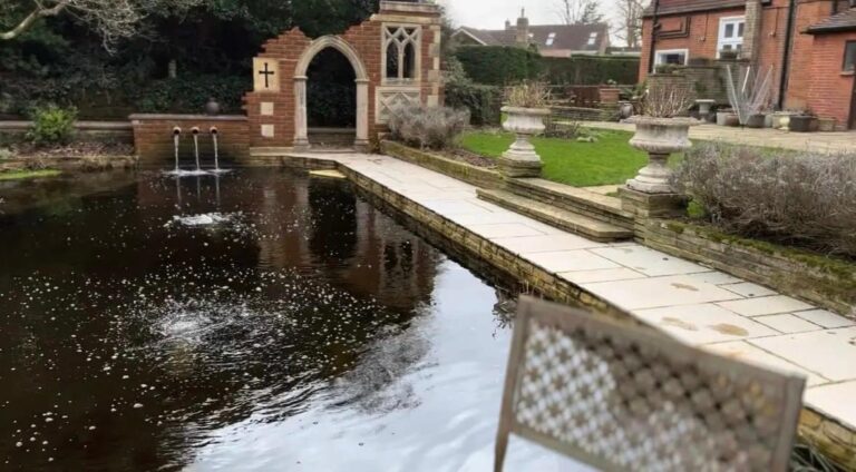 The traditional folly at the Cobham property, with the pond and surrounding limestone paved ring walk in the foreground